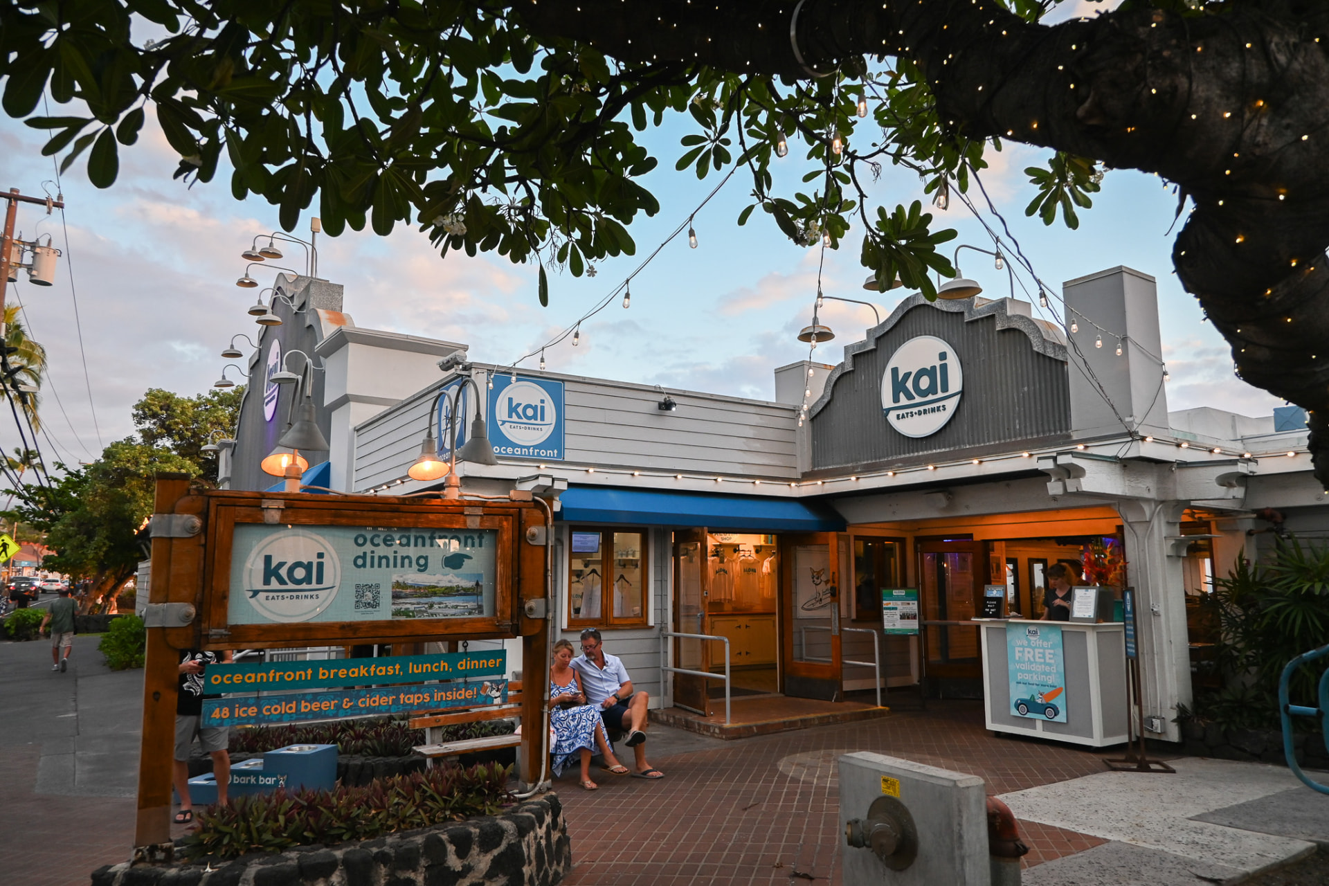 The Kai Eats + Drinks entrance in downtown Kona under string lights