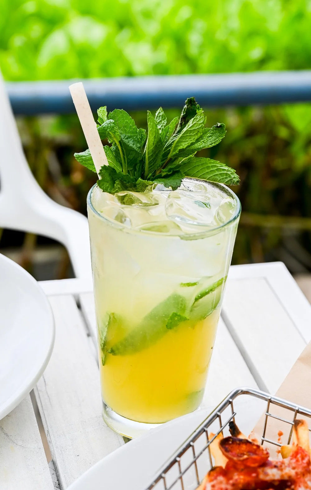 A tall citrus and mint drink on the oceanfront lanai