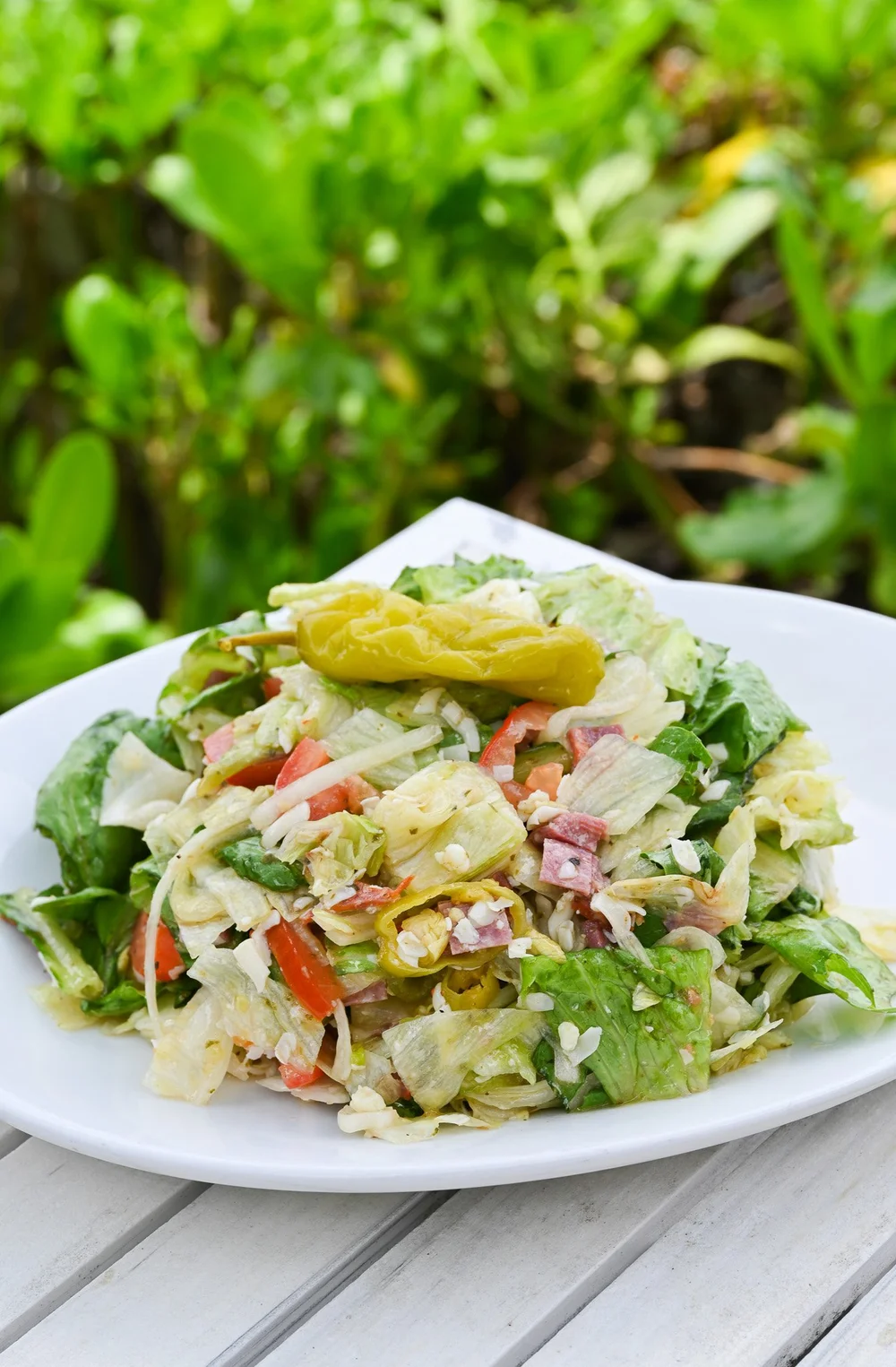 Chopped Italian salad with pepperoncini on a white plate