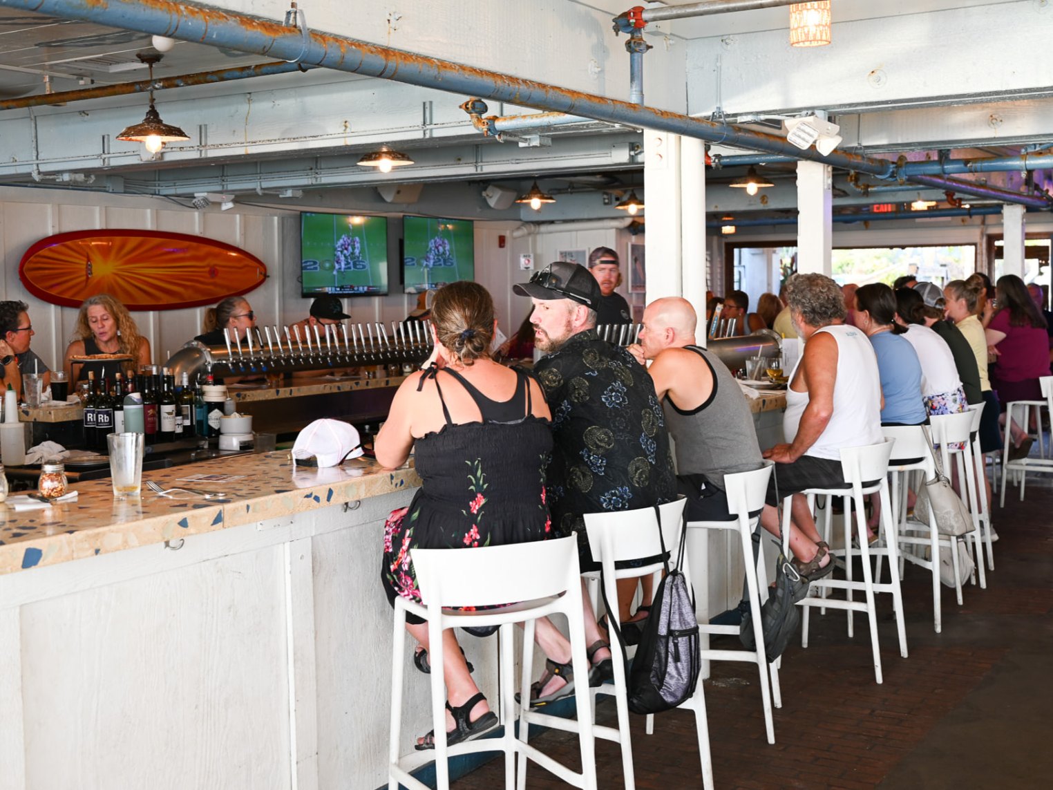 The indoor bar at Kai with 48 taps and a full row of guests